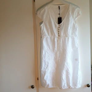 Ny Klänning  - Hur klänning med brodyr. Knytband i midja. Köparen står för frakten. 