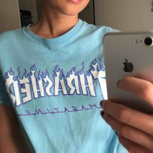  - Ljusblå thrasher T-shirt med lila flammor. Mycket bra skick knappt använd 