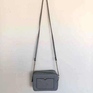  - Blå/grå väska med silvriga detaljer. Använd fåtal gånger. En fläck finns inne i väskan som visas på bild 3