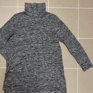 Grå vit snygg längre tröja med krage - Snygg grå vit längre långärmad tröja med hög krage. Jätte skön att ha på sig. Använd ett par gånger. 