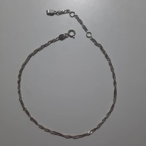 Fotlänk i silver från Glitter - Väldigt fin fotlänk i silver, tror jag köpte den för 149 kr. Sparsamt använd. Ca 22.5 cm till den första öglan och hela kedjan är ca 27 cm. Frakt 11 kr. Se min profil för fler smycken.