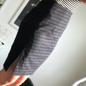 Svart slitsad kjol - Svart kjol med liten slits på ena sidan samt dragkedja. Använd en gång! Har undertyg och är lite ”tjockare” material. Över knäna på mig och jag är 167cm lång. Köparen står för frakten🖤