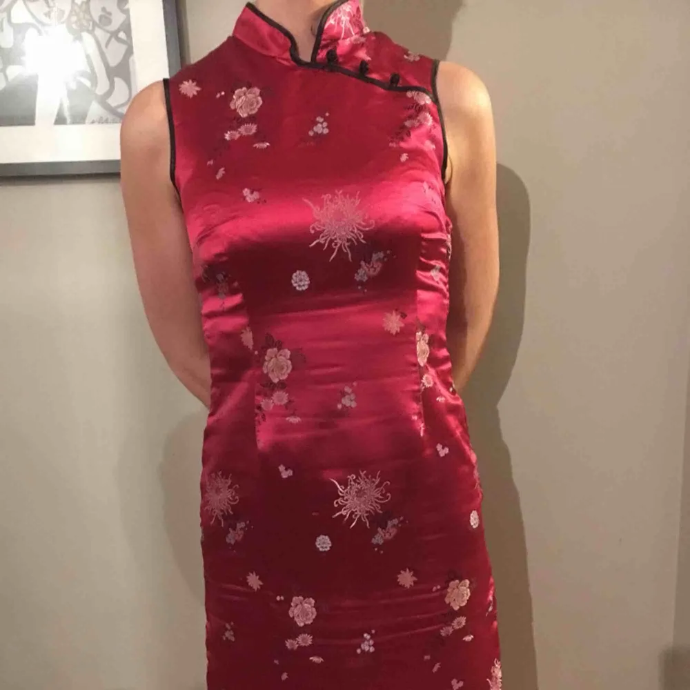 Rosaröd klänning med blommönster i kinesisk stil med fina detaljer och sidenmaterial . Klänningar.