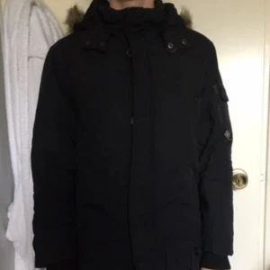  - En vinterjacka med pälskragsluva. Parkas jqcka