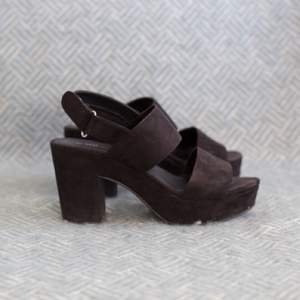 Svarta sandaletter från VOX i mockaliknande material. 9 cm hög klack, 3 cm platå fram och spänne med kardborreband. ☺️
