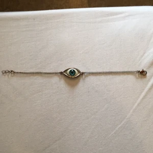  - Armband, öga. Ej äkta silver, har blivit kopparfärgad. (Se bild 3) Längd 18 cm utsträckt. (Se bild 1)