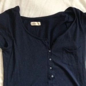  - Enkel marinblåa tröja ifrån Holister. Knappar fram och en liten ficka.  