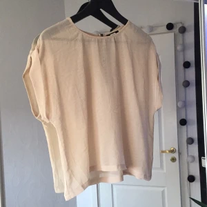  - Jättefin t-shirt/blus från BikBok, i en lätt genomskinlig nude färg, med blixtlås i ryggen. Jättebra nu till sommarn!