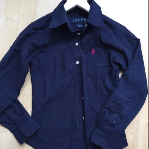  - Marinblå skjorta från Ralph Lauren (ej äkta) men ser äkta ut. Står att det är M men jag skulle säga att det är S. 