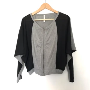  - Står ej storlek men som en XS/S. 95% bomull och 5% rayon (vet ej vad det är på svenska). Det svarta tyget är bara på framsidan och det är stumt. Passar både som kofta och tröja. Ca 52 cm lång, i nyskick