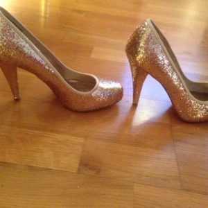  - Säljer ett par guldglittriga skor (pumps) i storlek 38 som ej är använda. Nypris 399 kr. Hör av er vid intresse! 