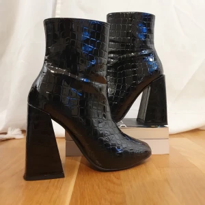 Sjukt snygga klackskor - Hög klack i fakekrokodil. Glansigt svarta, från Asos. Säljer pga fel passform för min fot. (Frakt tillkommer)