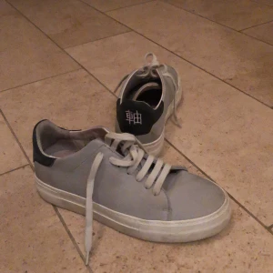 Axel arigato skor - Säljer mina supersnygga Axel arigato skor. Dem är gråa med en svart detalj bak. Dem är användna men i ett fint skick. Dem har en lite högre sula. Storlek 38. Priset är ink frakt.
