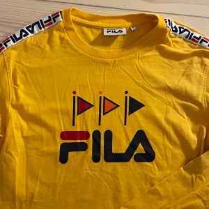 Fila tröja - Cool senapsgul (lite mer orange än på bilderna) kroppad filatröja. Väldigt skön men inte särskillt varm. Köpt på Urbanoutfitters för 400kr. Superbra skick. Priset inkluderar inte frakt men kan mötas upp i Sthlm💞 