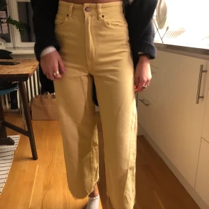 Jeans - Gula jeans utsvängda. Kort längd.