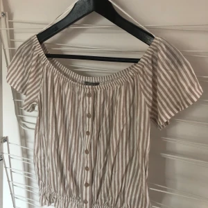 Randig topp Lindex XS - Beige & vit randig topp från Lindex. Storlek XS. Helt oanvänd. Skickar med postnords blåa kuvert