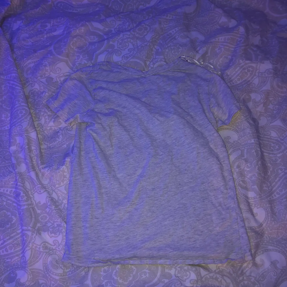 En grå T-shirt från H&M men ett litet nasatryck uppe i hörnet. Nästan aldrig använt så skick 9/10. Den kostade runt 99kr när jag köpte den. I strl xs är den. . T-shirts.