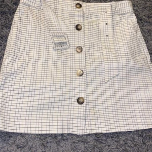 Kjol från NAKD - säljer nu en jättefin kjol med lite ränder i svarta och gula färger. Sitter jättefint över rumpan och använd 1 gång 