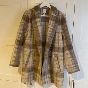 Rutig kappa från H&M - Fin rutig kappa från H&M i storlek 38, inte använd speciellt mycket alls! Väldigt skön och snygg kappa som passar till mycket. Är 173 och storleken är normal