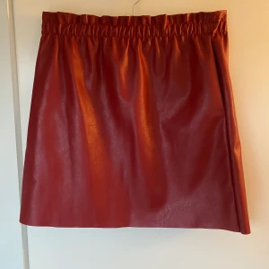 Oanvänd kjol i fakeskinn - Jättefin röd kjol med resår i midjan. Aldrig använd! Köpt på Raglady by Tara. Nypris 399kr. Kan mötas i Kungsbacka alternativt köparen står för frakt :)