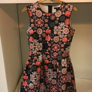  - Sockersöt klänning med smyckesmönster. Knappt använd!