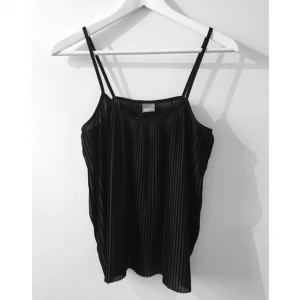  - Plisserat linne, sparsamt använt, inte så genomskinligt, sitter oversized och löst mot kroppen.