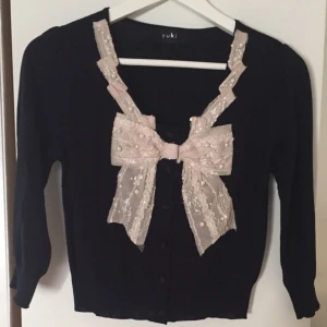  - Svart kofta med knäppning och rosett framtill. Står tyvärr ingen storlek men skulle gissa på Small. Köpt på bloppis av Blondinbella och sedan aldrig använd. 
