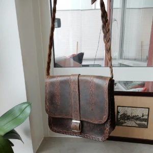  - Läderväska som jag har fått av min mamma som i sin tur också har använt den, därav lite sliten. Dock otroligt fina mönster och detaljer, långt, flätat och justerbart axelband. Ett endaste fack. Superfin till sommaren! 😊