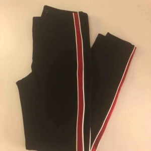  - Svara Tights med rött streck på sidan  Storlek S  På bilden kan de se korta ut men de är långa. Väldigt stretchiga  Vända få tal ggr Köparen står för frakt  Betalas helst med swish 