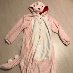  - Skönaste kigurumin som föreställer en rosa dinosaurie! Använd sparsamt. Kan skickas, FRI FRAKT!!🤠