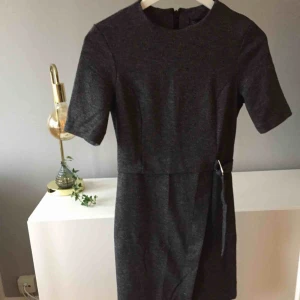  - Fin gråmelerad fodralklänning med skärp i midjan