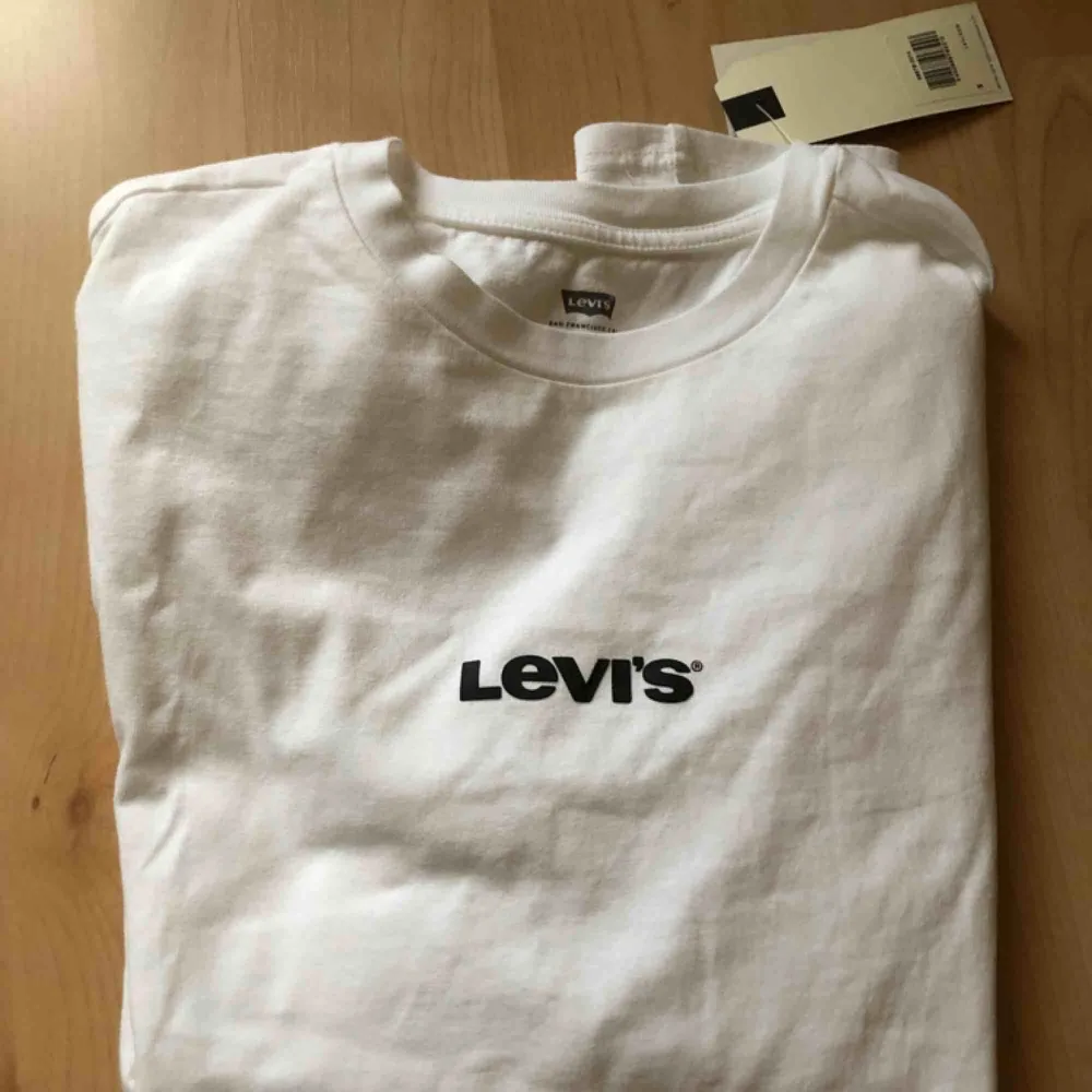 Vit Levi’s T-shirt med grått tryck stl s. Helt ny, lapp kvar! Ordpris 250:-. T-shirts.