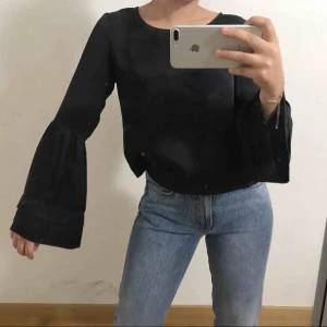 - En super snygg svart silkes tröja med trumpet ärmar, super snygg till hösten