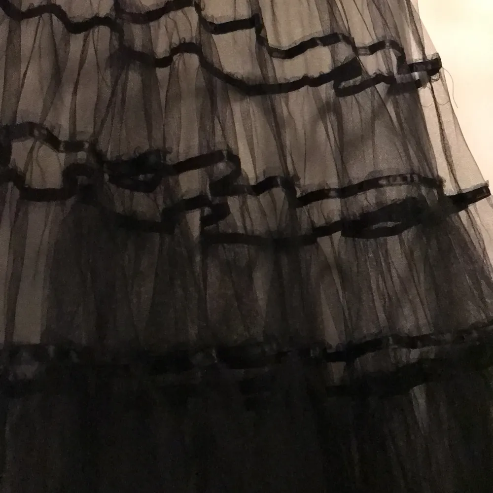 Kjolen passar stl small, är 103 cm lång och har en vidd av hela 15 m. Den kan antingen användas som underkjol, eller användas som den är. Den är sydd i våder som dekorerats med svarta satinband. Den vackraste tyllkjol du kan få. Kjolar.