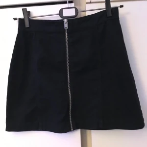 Svart kjol - Snygg svart kjol med dragkedja på mitten från HM. Säljer för att jag knappt har använt den. Frakt tillkommer. 