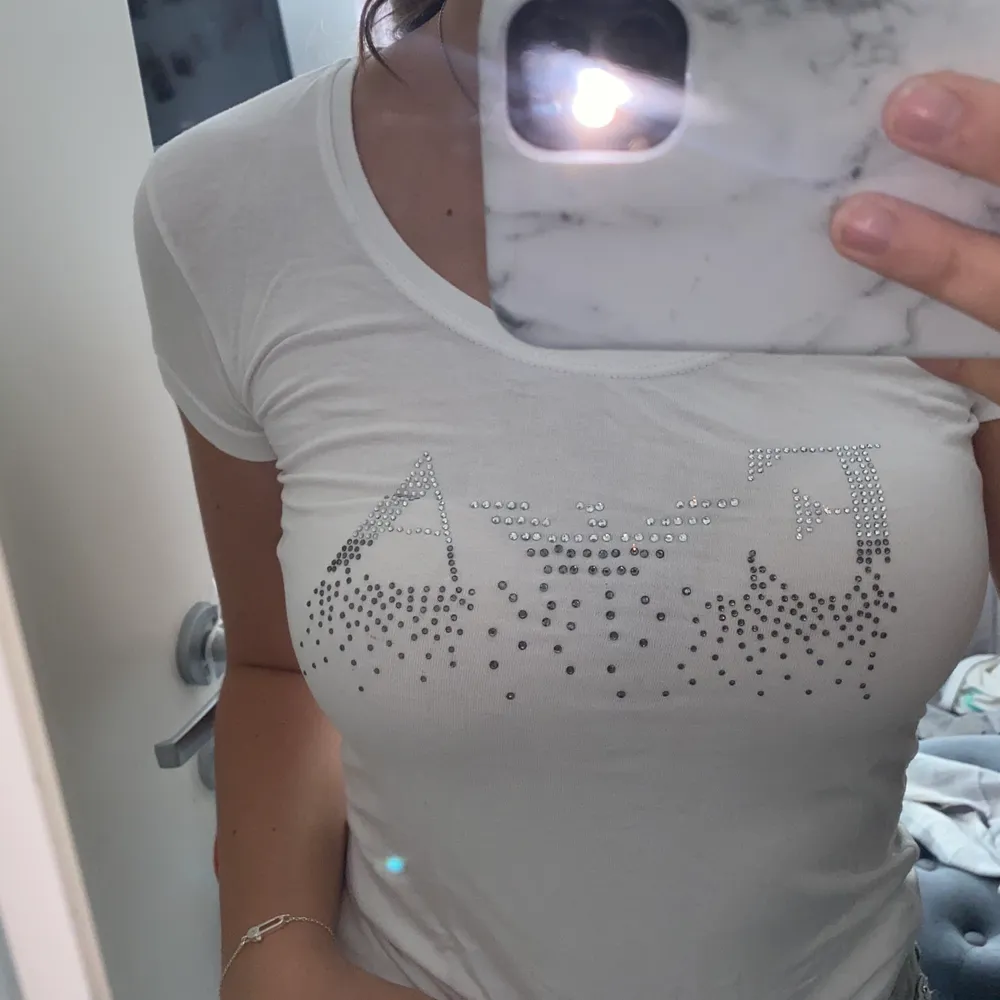 En äkta vit Emporio Armani t-shirt, nästan helt oanvänd och har tryck på bröstet. Den är i storlek XS/S. T-shirts.