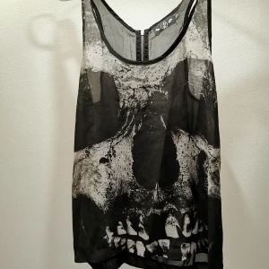 Svart mesh line - Svart mesh line, med tryck på en döskalle. Luftigt och snyggt, inte allt för genomskinlig. 