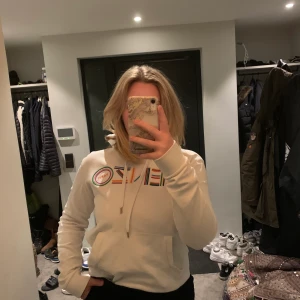 Kenzo hoodie  - Vit kenzo hoodie med färgglad text. Använd ett fåtal gånger. Är i storlek XS för herr men sitter superbra för dam. Nypris 3000kr. Köparen står för frakten 95kr. Kan gå ner i pros vid snabb affär.💕🥂