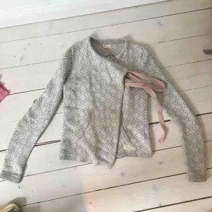  - Ljusgrå/vit Odd Molly -kofta med rosa band och fint mönster. Storlek 0 som motsvarar XS ungefär. Jäättefint skick, använd men ser verkligen ut som ny. Nypris ca 1500