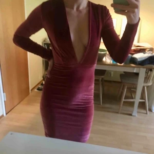 Vinröd urringad sammetsklänning  - Vinröd sammetsklänning med djup urringning från Nelly. Endast använd en gång! Frakt: 44 kr