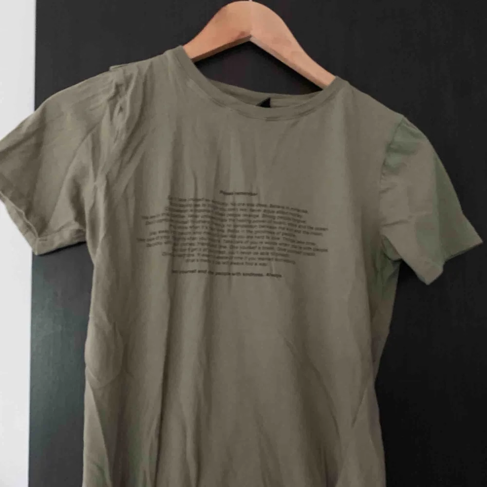 Militärgrön t-shirt med text. Bara använd en gång. T-shirts.