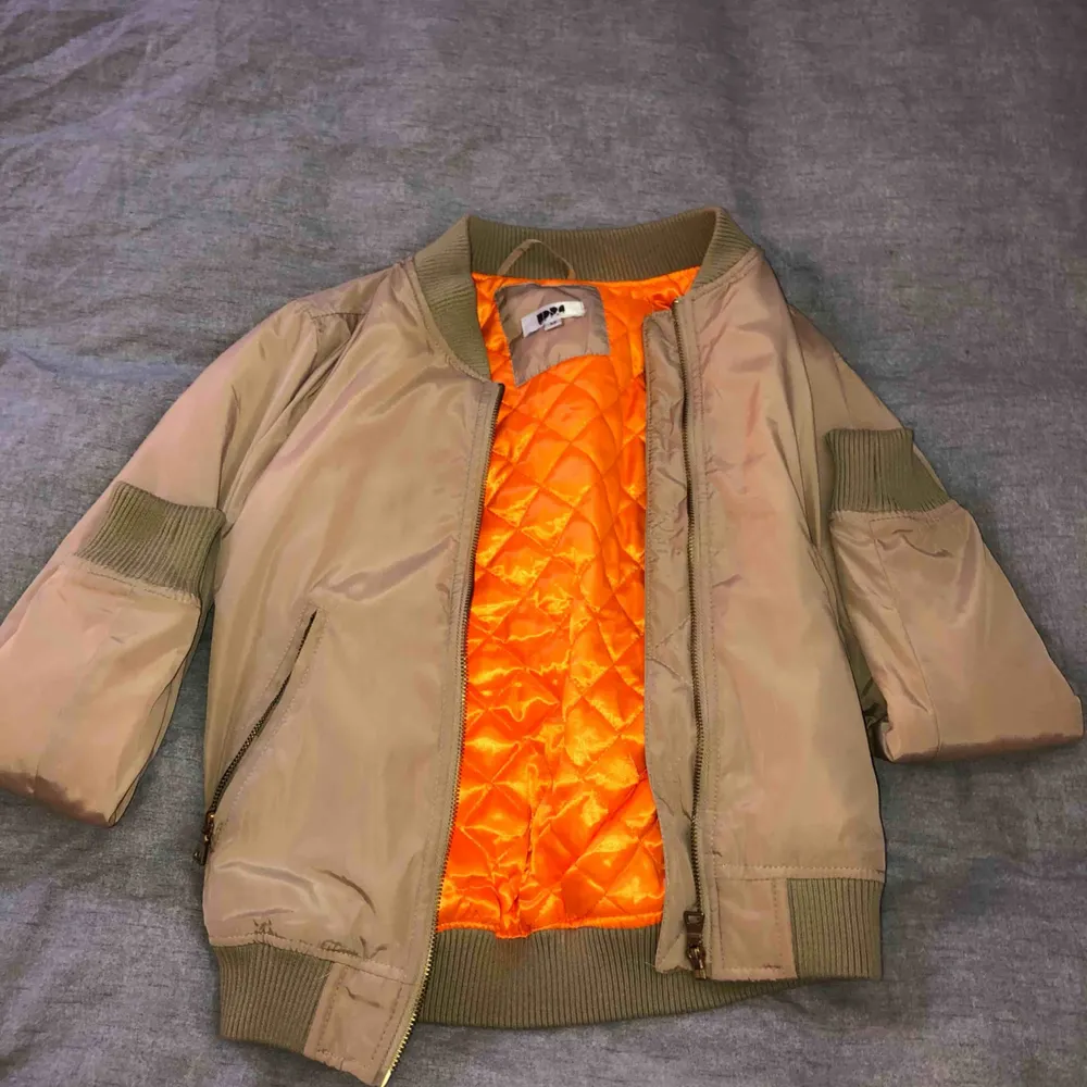 Beige bomberjacka som aldrig är använd. Frakt ingår i priset. Insidan på jackan är orange. Jackor.