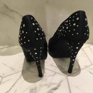  - Snyggaste festpumpsen! Svarta med stenar i strl 39. Slitage på bl a klack men ändå i fint skick. Någon sten har lossnat. Snyggaste skorna som man garanterar har kul i! 