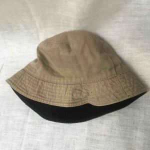  - Fin buckethat som man kan vända ut och in på! Du kan alltså ha den svarta sidan upp eller den beiga :) gott skick. Möts i stockholm. Priset är exklusive frakt