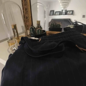  - Sparsamt använda kritstrecksrandiga byxor.  Inget fel på dom, de är bara för små. 