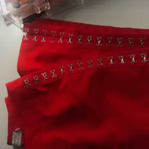 Na-kd X Sahara Ray byxor, röda med silver spännen som man kan öppna hur lång upp man vill. Knappt använda, jättefint skick