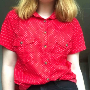  - Röd prickig blus/skjorta aldrig använd så därav väldigt bra skick.  Köparen betalar frakt