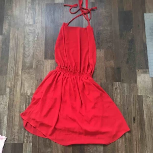  - Jätte fin röd klänning med öppen rygg som man knyter i nacken. Sitter jätte fint på. Använd 1 gång. Köpt i Portugal så minns ej affären. Frakt tillkommer.