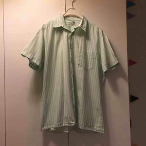 Köpt på second hand, aldrig använd. Mintgrön-vit skjort blus med korta ärmar. Kan mötas upp eller skicka. 