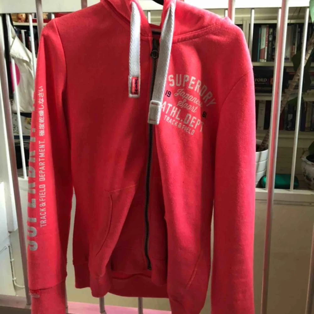 Neon rosa zip-Hoddie i bra skick från Superdry.  Storlek XL, känns mer som en L.  Ändvänd ett fåtal gånger. Jag säljer den för 280 kr, original pris 600 kr.. Hoodies.